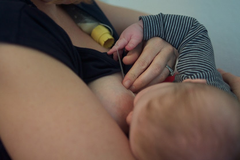 Mother feeding baby with SNS method